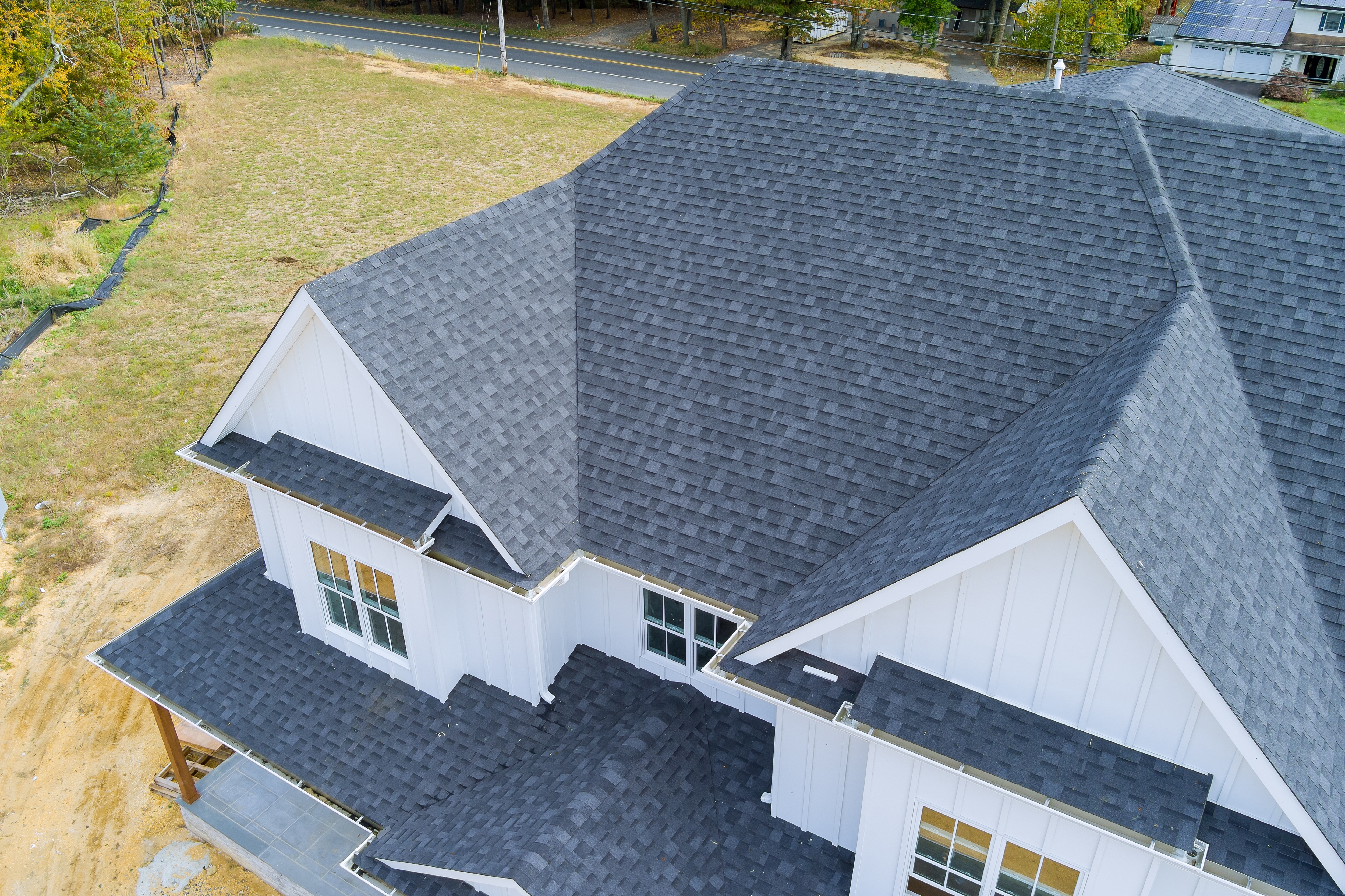 Aerial drone shot of new white farmhouse roof installation